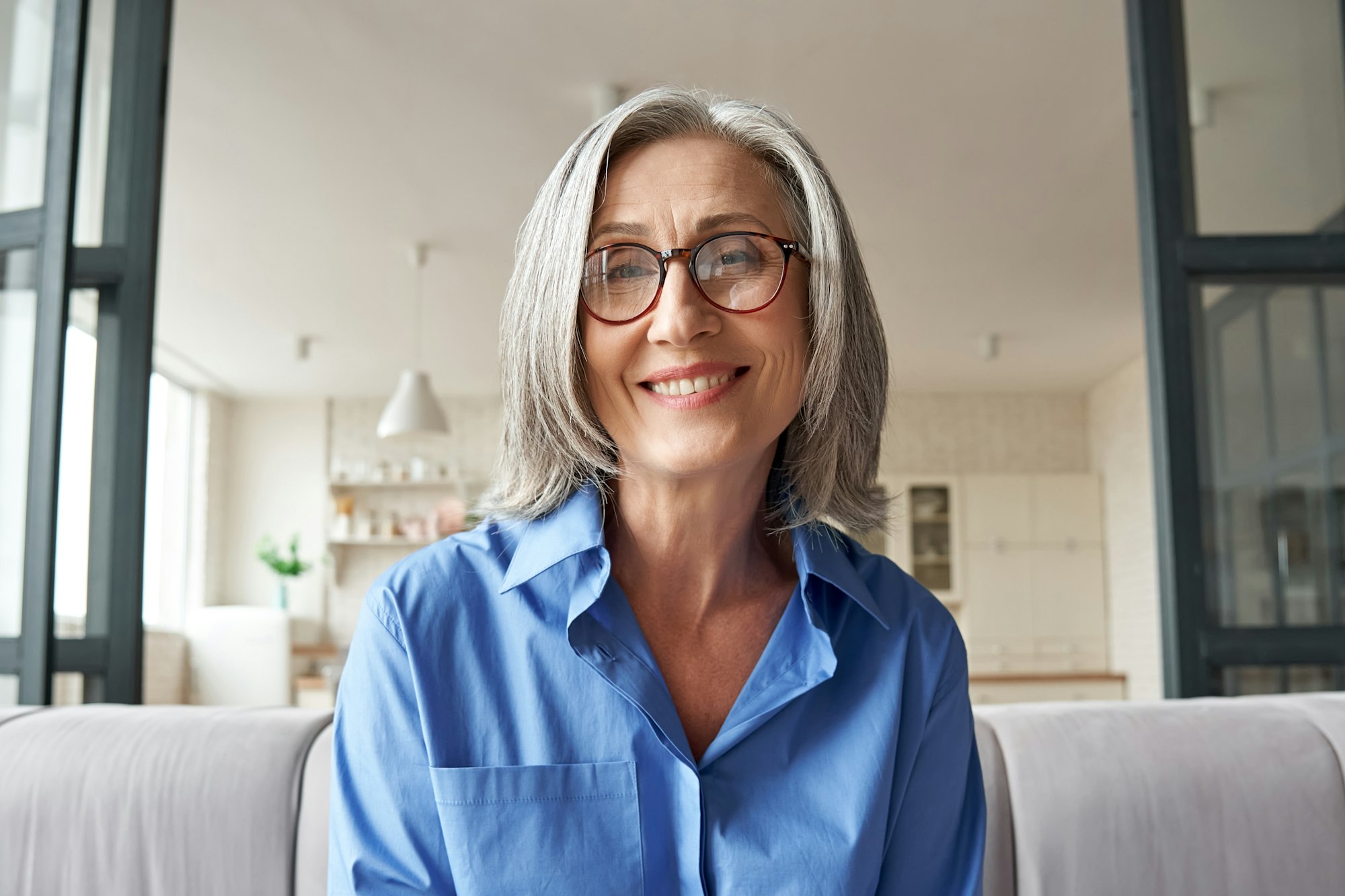 Smiling mature older woman looking at camera, webcam headshot.